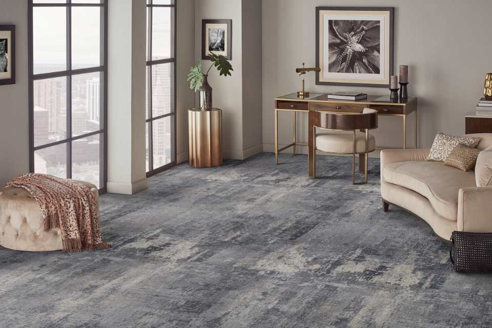 dark gray and blue patterned carpet in formal sitting room with gold accents and velvet furniture